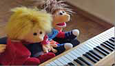Zwei Puppen spielen Klavier