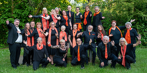 Gruppenfoto des Chors mit orangenen Schals
